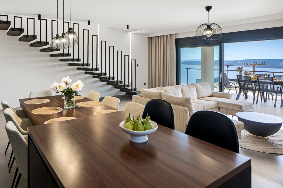 The living room features glass walls that allow for beautiful views and ample daylight