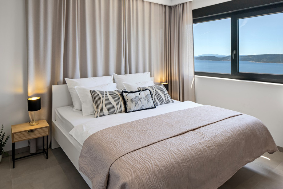 Bedroom No. 1 (18 sqm): Features a king-size bed (180 cm x 200 cm), a TV, A/C, and panoramic sea and island views.