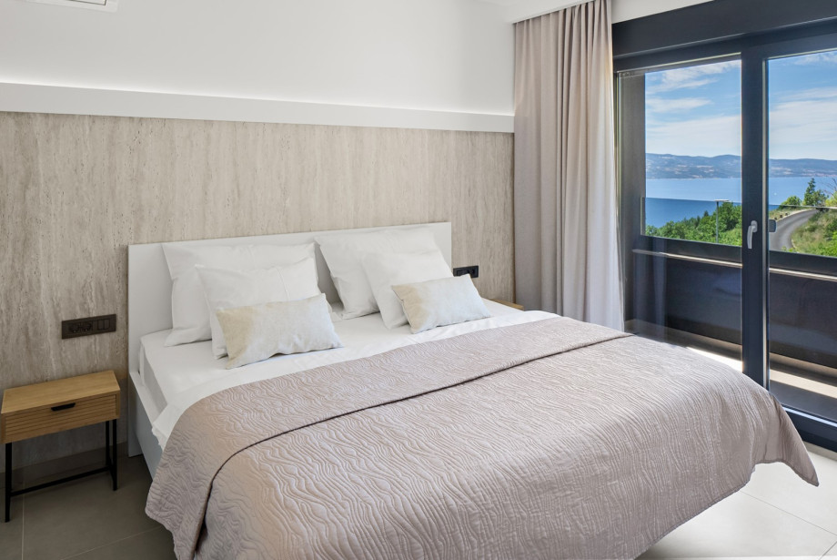 Bedroom No. 2 (14.5 sqm): Includes a king-size bed (180 cm x 200 cm), a TV, A/C, and views of the sea and mountains