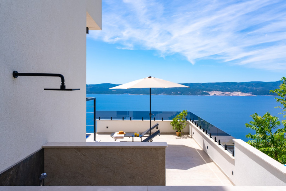 An outdoor shower next to the pool area.