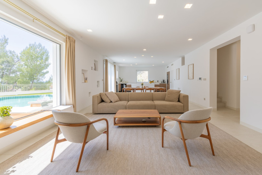 Helles, offenes Wohnzimmer mit edlen Möbeln von Prostoria und Artisan, großen Fenstern und herrlichem Blick auf das Meer und die grüne Umgebung