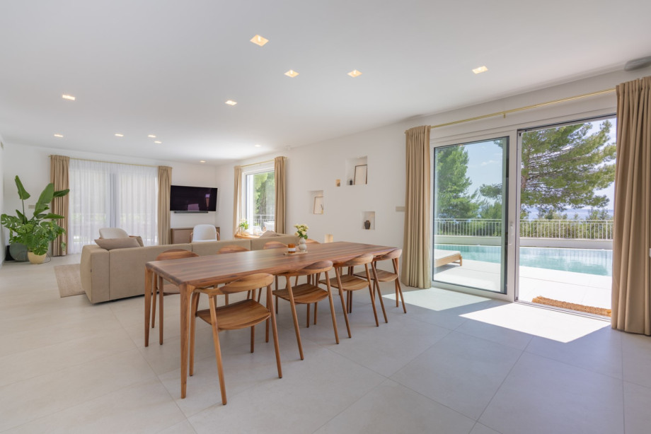 Eleganter Essbereich mit Möbeln von Artisan, einem geräumigen Holztisch und direktem Zugang zur Poolterrasse