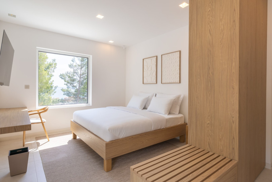 Das minimalistische Design, das bequeme Bett und das natürliche Licht schaffen eine ruhige Atmosphäre für erholsame Nächte.