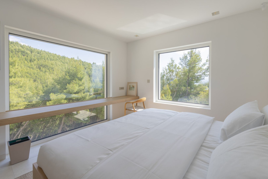 Schlafzimmer Nr. 4 mit Kingsize-Bett (180 x 200 cm) bietet ein helles und ruhiges Schlafzimmer mit großen Fenstern und Blick auf Pinien und mediterranes Grün.