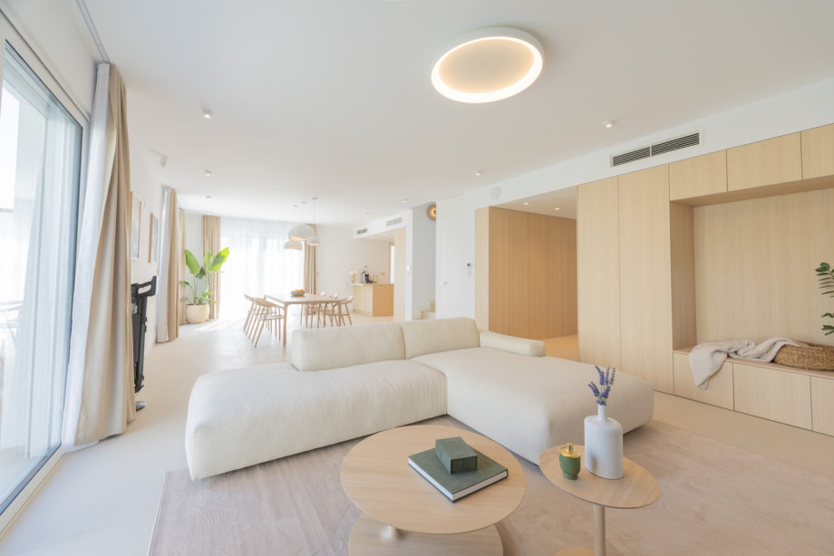 Bright living room with a soft designer sofa from the renowned Croatian furniture brand Prostoria, natural textures, and direct access to the outdoor terrace