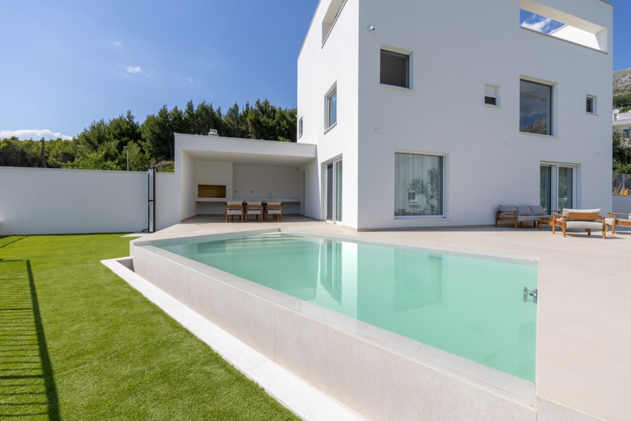 Private pool terrace with high-quality designer teak furniture from Fjaka, open sea views, and a bright Mediterranean setting