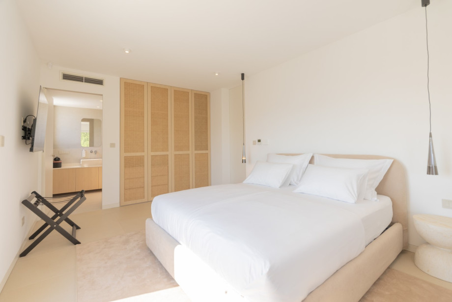 The minimalist design, comfortable bed, and natural light create a calm setting for restful nights