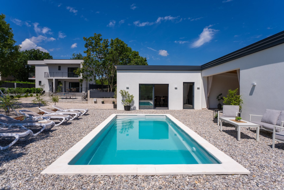 Surrounding the pool is a spacious sun deck covered with pebbles, furnished with eight deck chairs, a lounge corner.