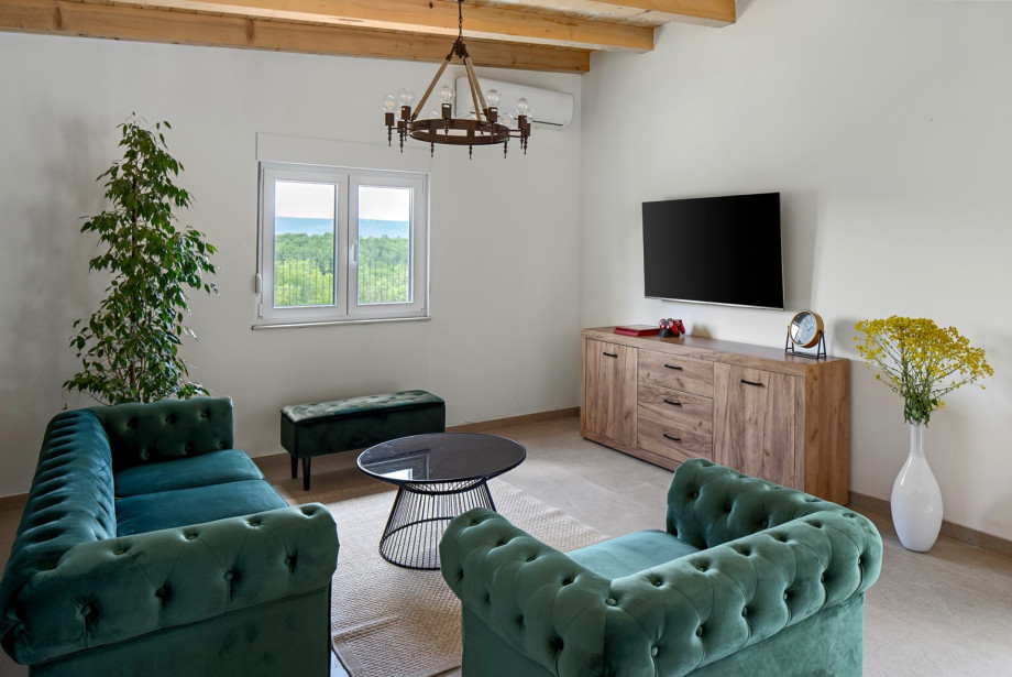 Lounge corner with a flat-screen TV, air conditioning, and a PlayStation 4 for entertainment.