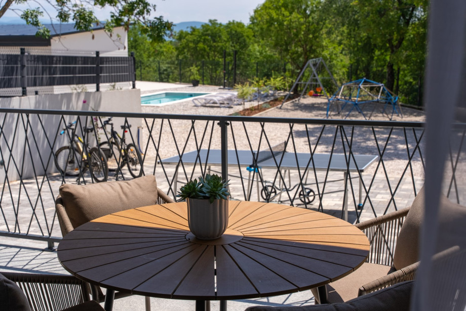 This inviting space includes a terrace with a coffee table, offering lovely views of the pool.