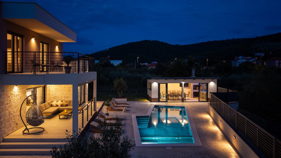 The villa offers a covered outdoor dining area positioned right next to the pool area.