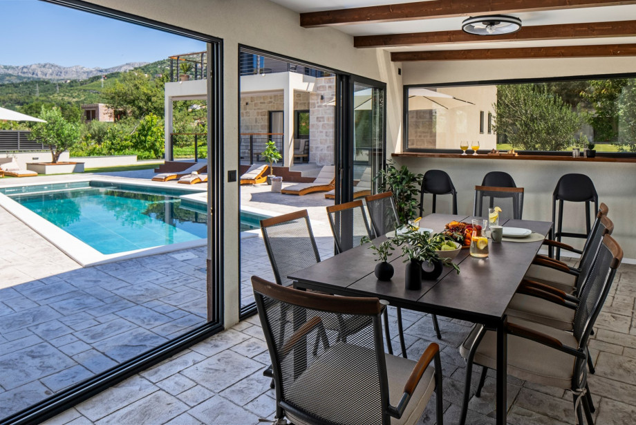 Covered outdoor dining area for 10, ideal for al fresco meals and mornings by the pool.