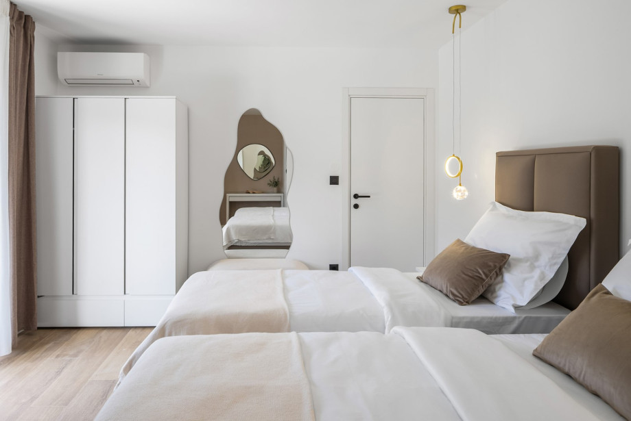 Stylish bedroom with a king bed (separable into twins) and a unique designer mirror.