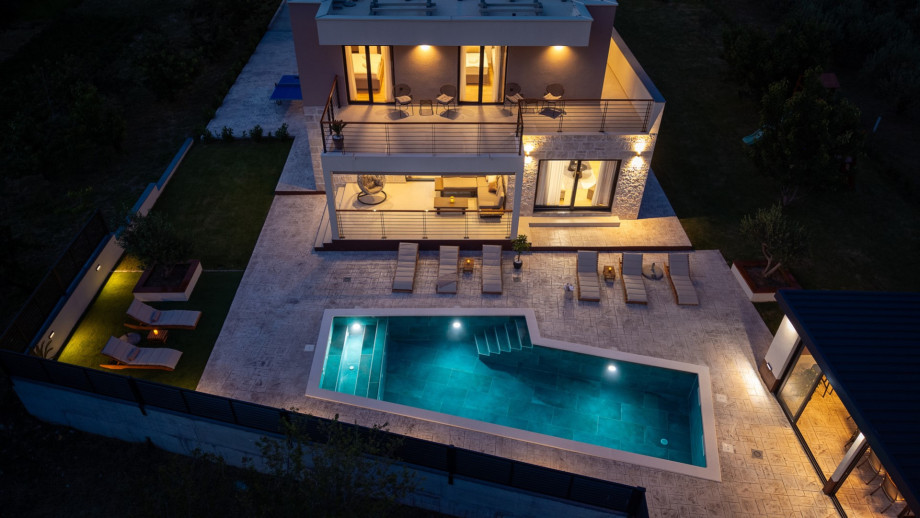 Evening ambience by the pool and covered outdoor dining area, perfect for sunset and BBQ.