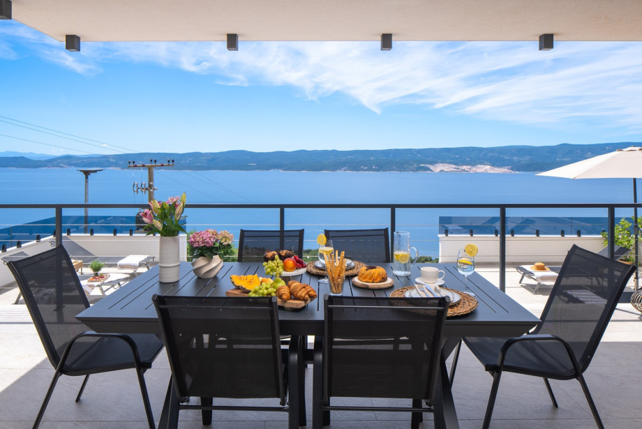 A charming covered outdoor dining area is positioned a few steps above the pool