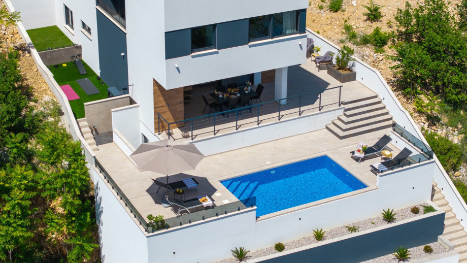 With 226 sqm of useful interior space organized across three levels, this villa sits on a private plot of 450 sqm