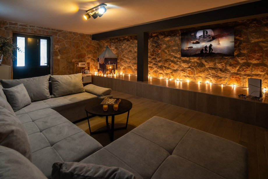Der 30 m2 Medienraum bietet eine PlayStation 5 und ein Sofa.