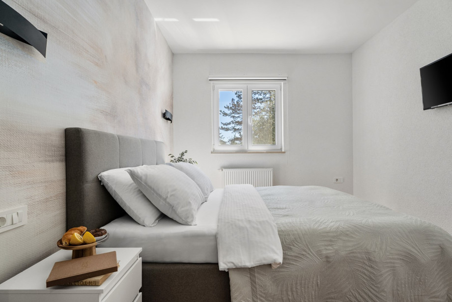 Schlafzimmer 3 ist 17 m2 groß und bietet ein Queen-Size-Bett sowie einen TV.