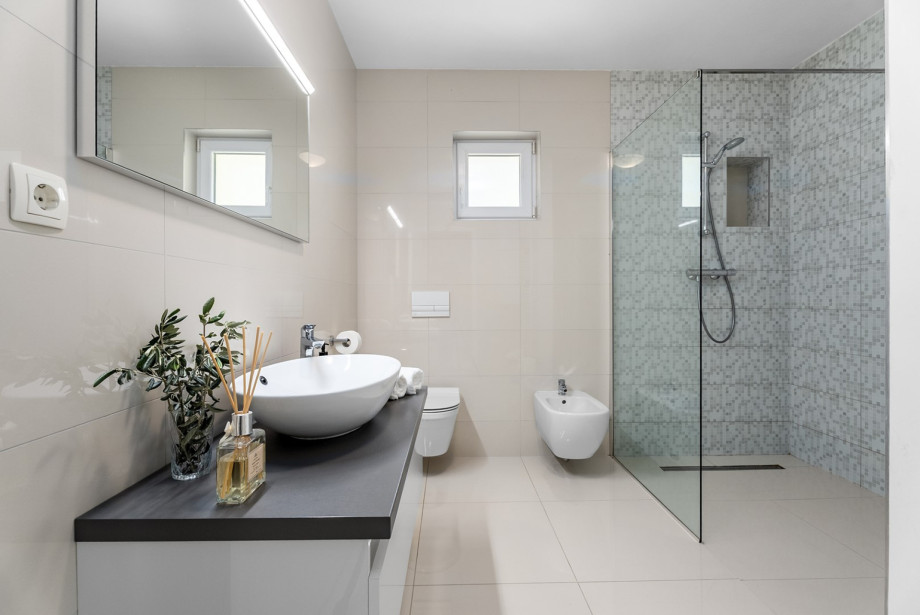 Das Familienbad bietet eine geräumige Dusche und ein Bidet.