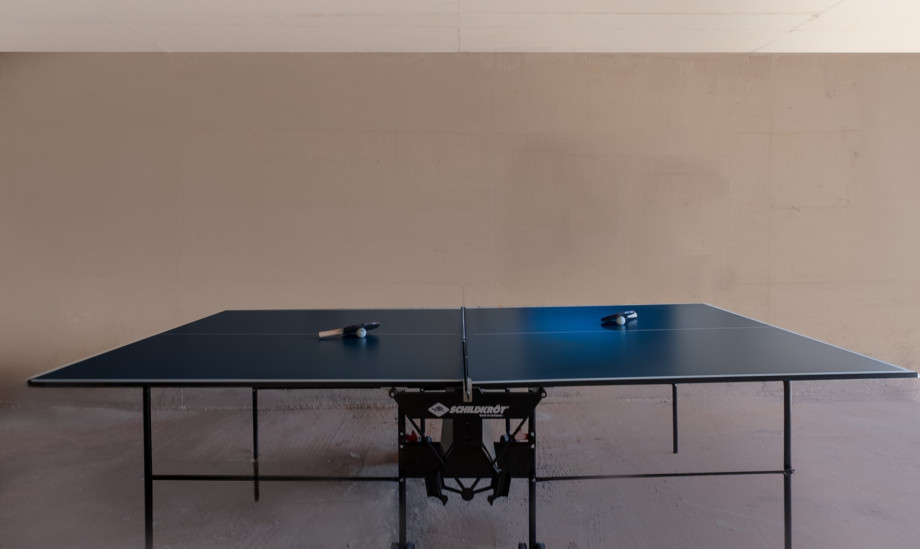 Die Outdoor-Tischtennisplatte befindet sich in einem überdachten Außenbereich.