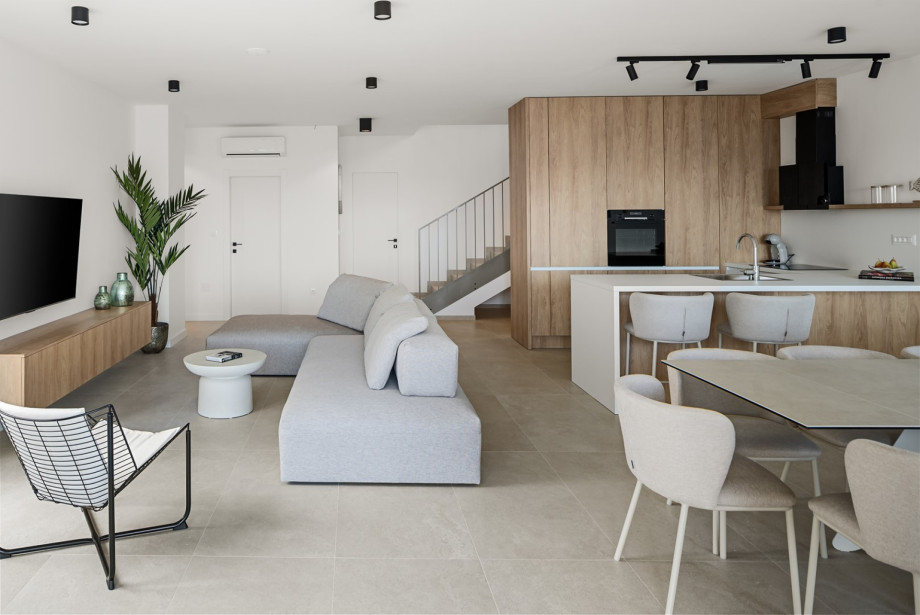 Lounge area features a cozy sofa and a large flat-screen TV.
