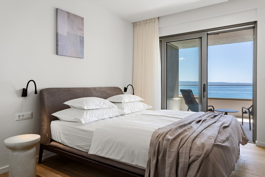 Balcony comes with lounge chairs and panoramic sea views.