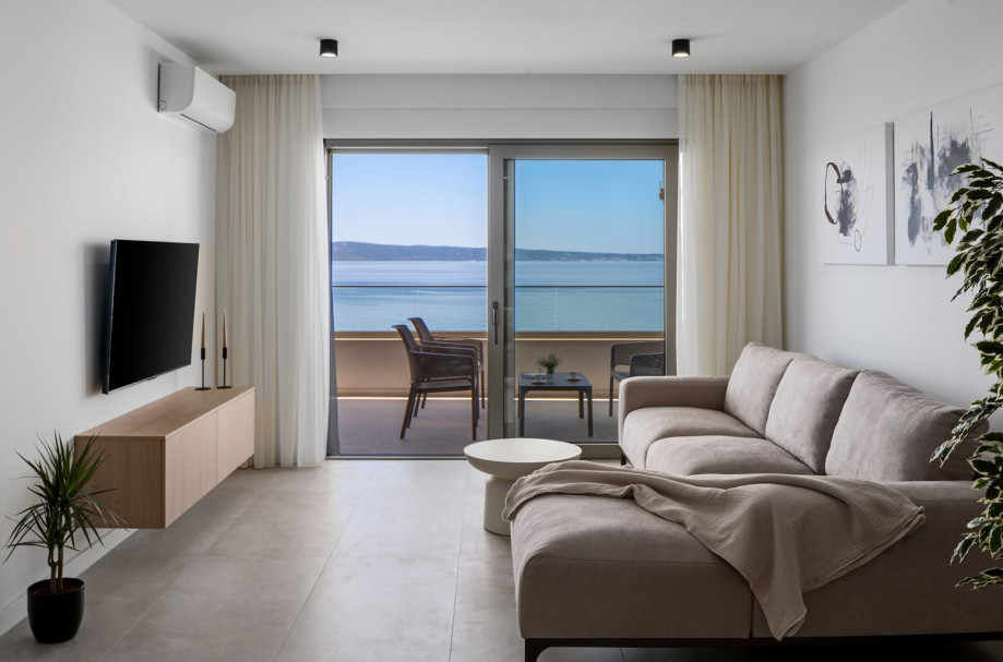 Upper living room features a flat-screen TV and a comfortable sofa.