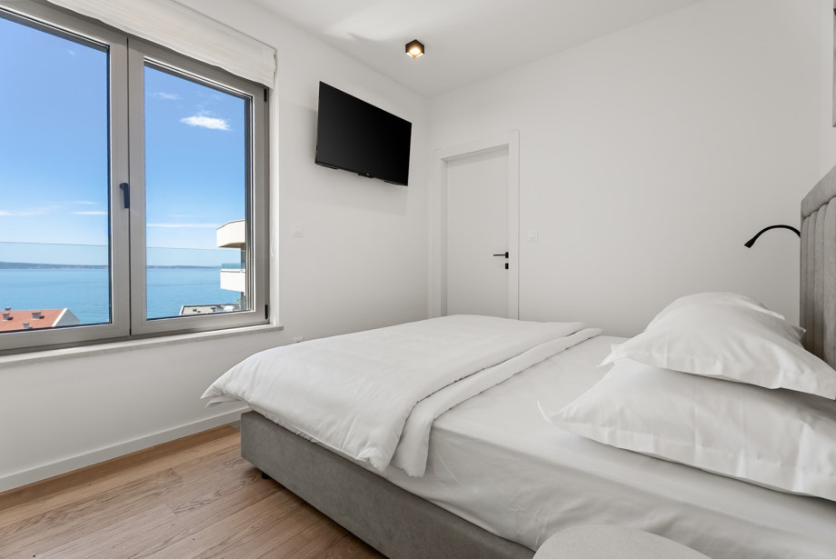 King-size bed faces the window to offer lovely views of the sea.