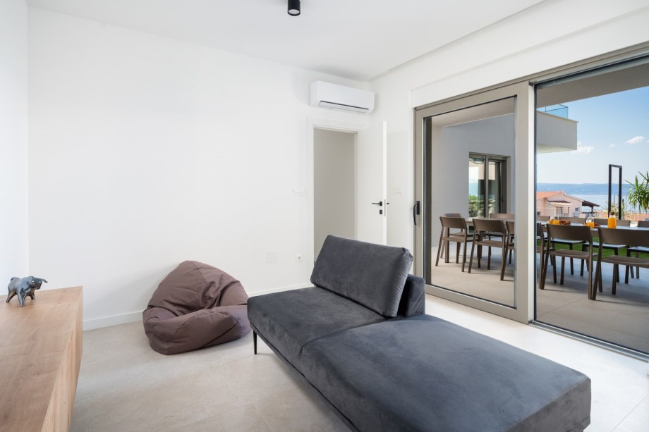 Media room features a sofa, TV, and direct pool access.