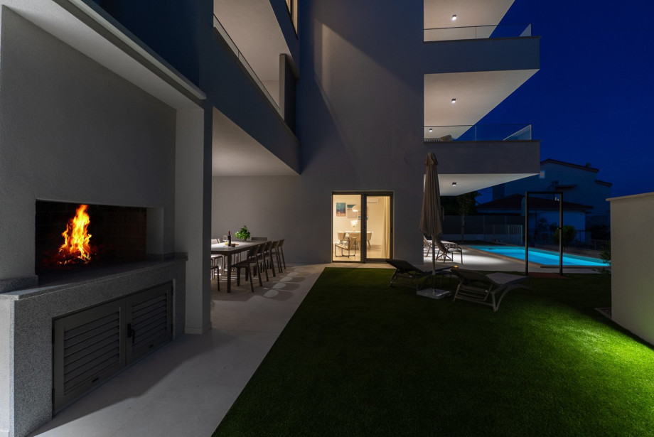 Outdoor dining area features a dedicated wood and charcoal barbecue.