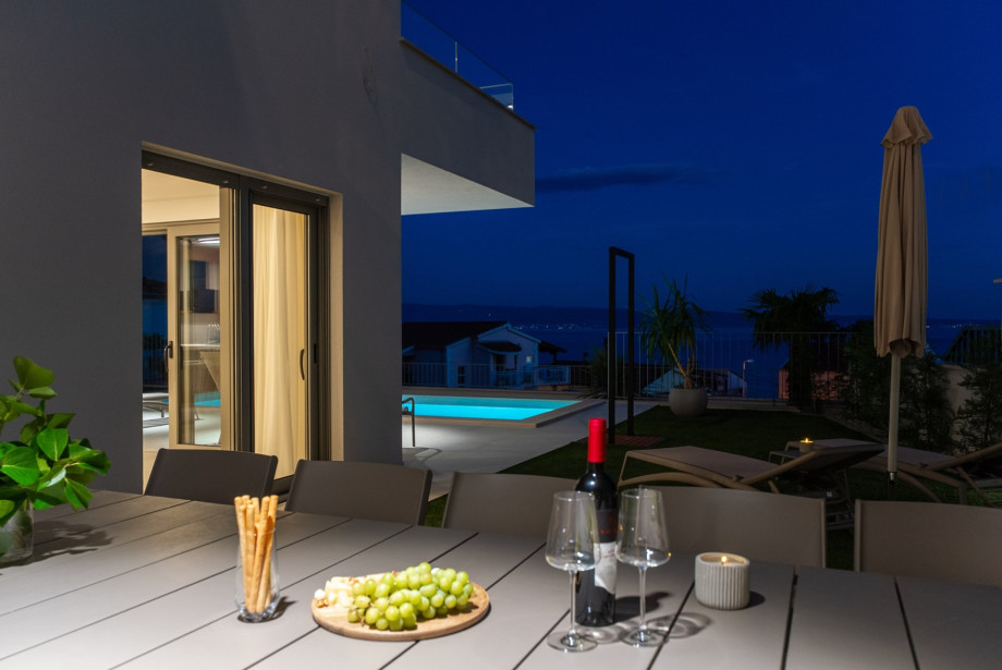 Covered outdoor dining table sits just steps away from the swimming pool.