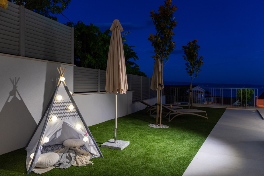 Kids' play corner with a tent and toys is positioned next to the sun deck.