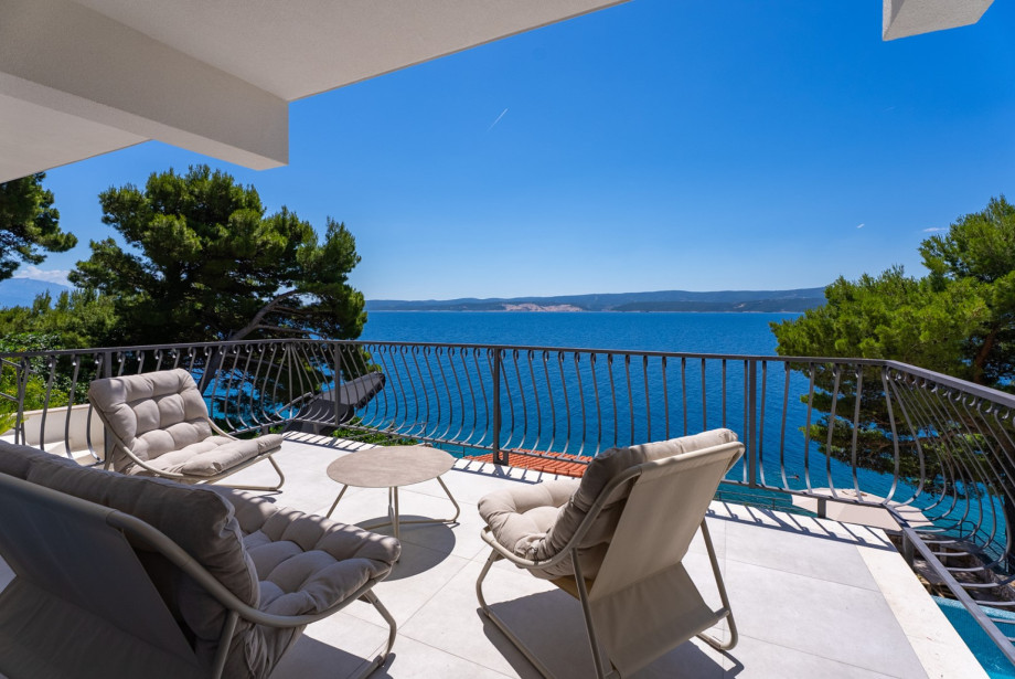 Living room opens up onto a spacious upper terrace with a dedicated lounge corner.