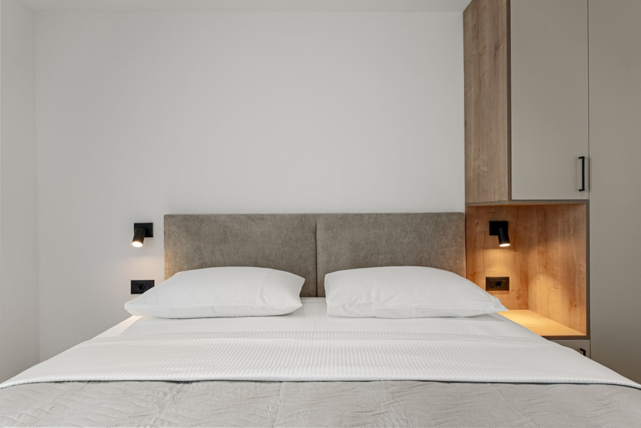 Room includes a flat-screen TV and a wardrobe.