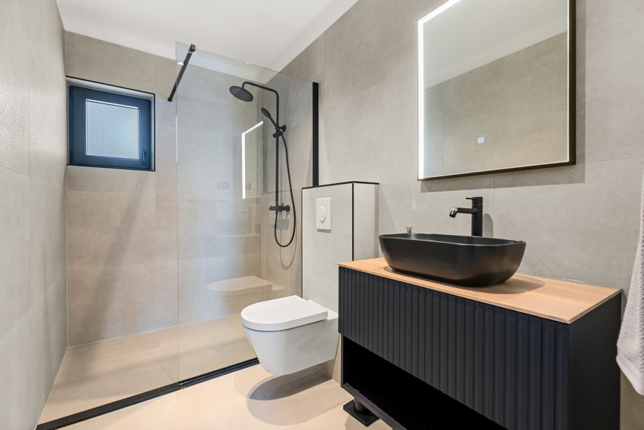 Attached en-suite bathroom is fully equipped with a modern shower setup.