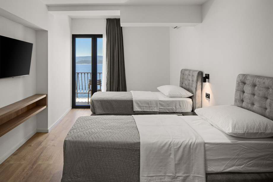 Sliding doors open directly onto a furnished terrace with chairs.