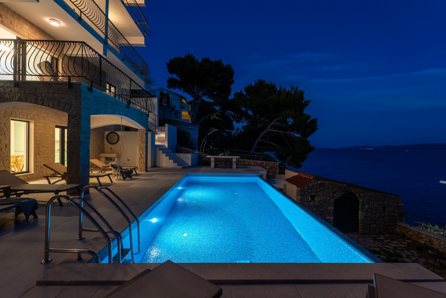 Glass sliding doors create a seamless connection between the pool and the ground floor.