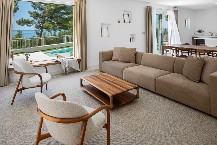 Within the villa, natural light floods the space, elegantly showcasing a modern aesthetic