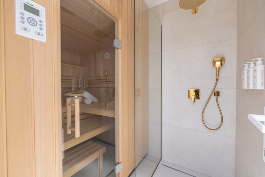 Wellness bathroom with a private sauna, walk-in shower, gold-toned fixtures, and award-winning Natura Bissé cosmetics