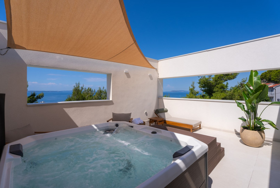Rooftop wellness terrace with a private jacuzzi, shaded lounge area, and open views of the sea, Split, and the islands