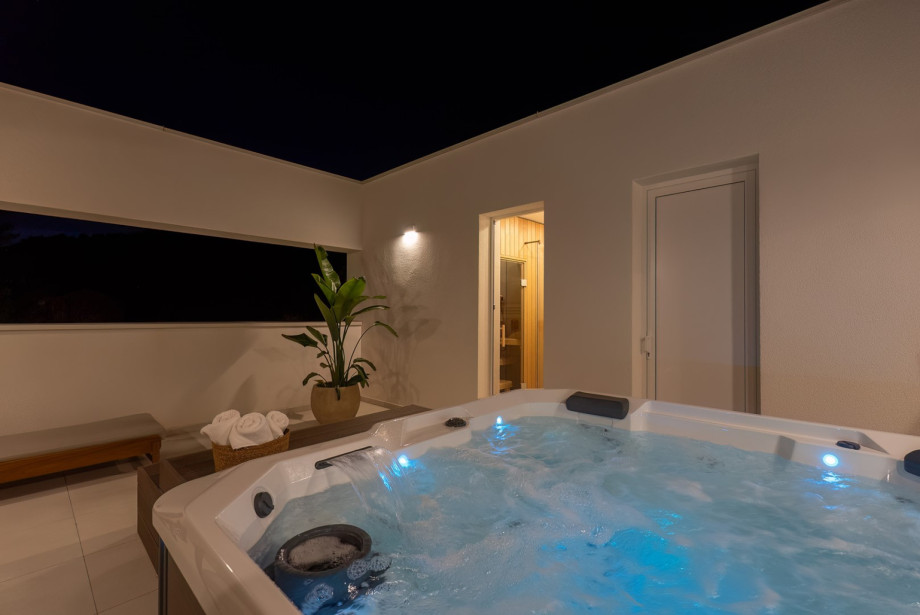 Rooftop wellness terrace with a private jacuzzi, shaded lounge area, and open views of the sea, Split, and the islands