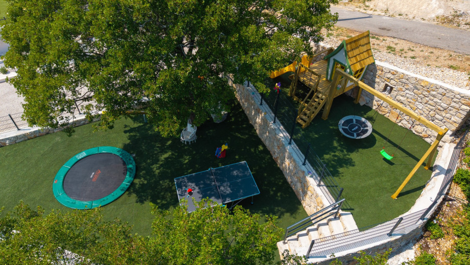 The outdoor space also features a lush garden with seasonal vegetables for guests to enjoy, along with a fenced grass playground that provides a safe space for children.