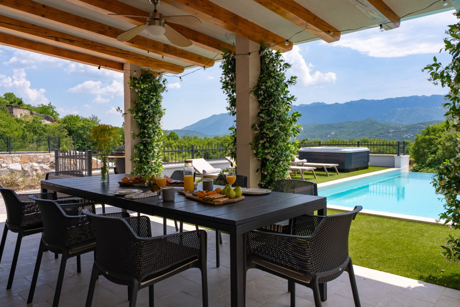 For outdoor dining, there is a covered area with a barbecue, an outdoor bar with a fridge and ice maker, and a dining table that seats eight