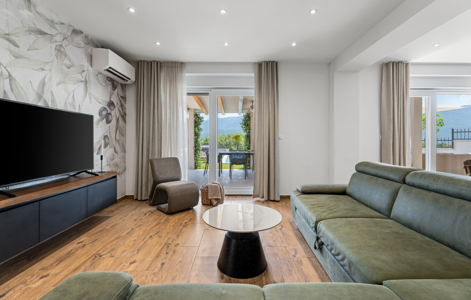 Spacious air-conditioned living room with comfortable sofa and TV