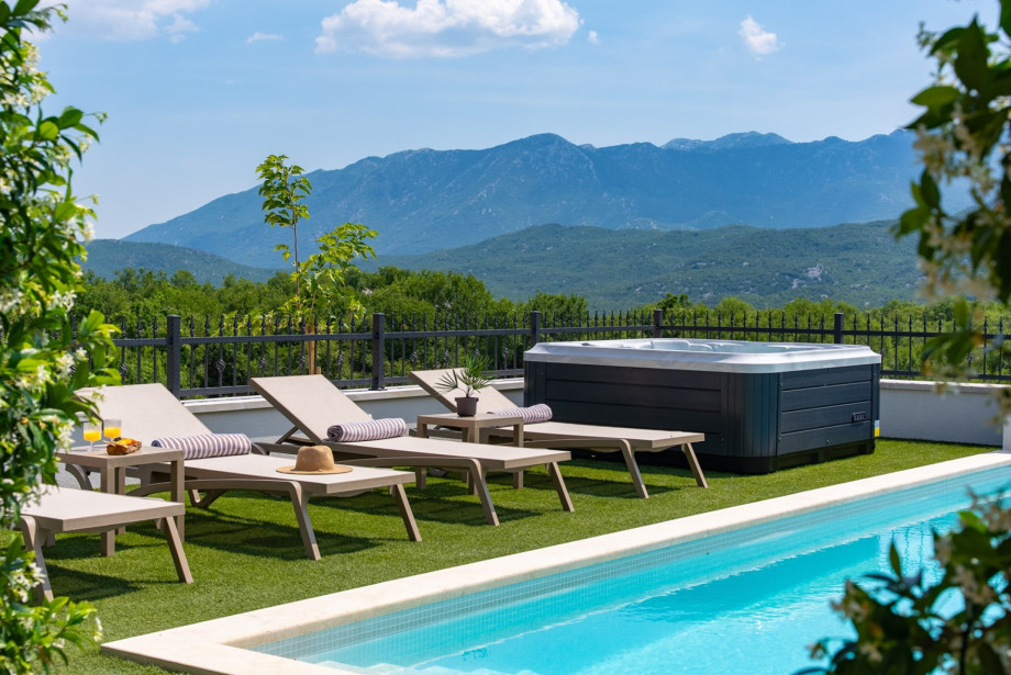 Adjacent to the pool, there is an outdoor Jacuzzi, or hot-tub, offering breathtaking views of the surrounding natural landscape