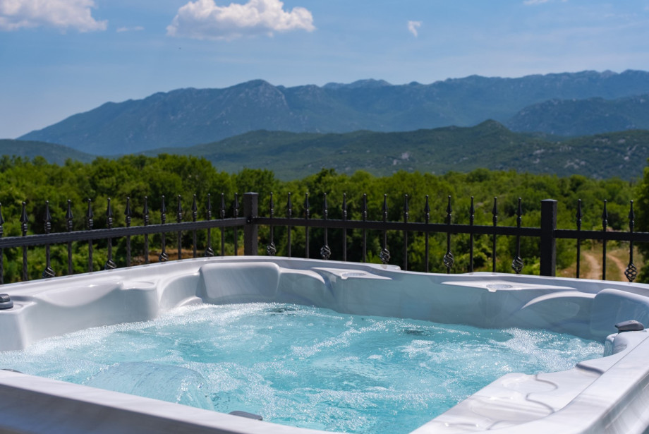 Adjacent to the pool, there is an outdoor Jacuzzi, or hot-tub, offering breathtaking views of the surrounding natural landscape