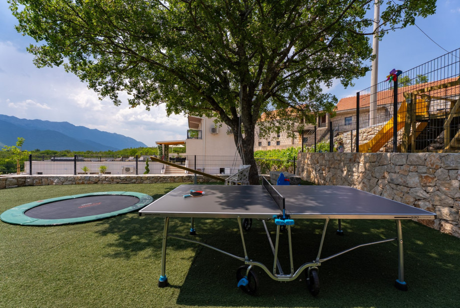 This playground is fitted with a table tennis, a trampoline, a kids climbing house, a seesaw, a slide, and swings, making it a perfect spot for younger family members to play.