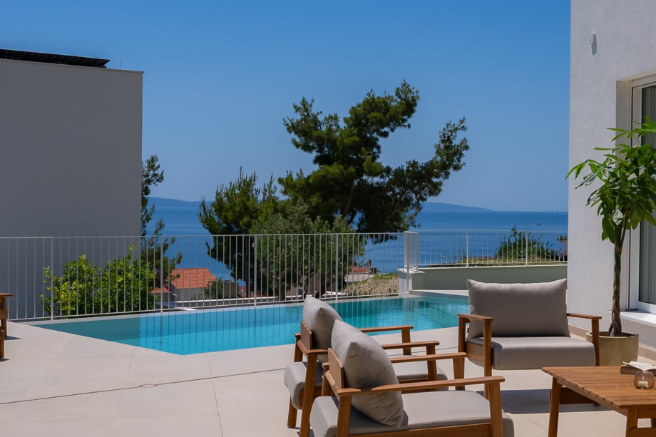 Private Poolterrasse mit hochwertigen Designer-Teakholzmöbeln von Fjaka, freiem Meerblick und hellem mediterranem Ambiente