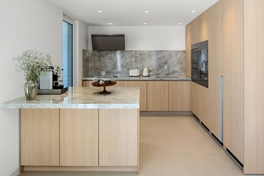 Die voll ausgestattete Küche ist ein kulinarisches Paradies mit edlen Quarzoberflächen und modernsten Geräten von Miele und Smeg, die Ihr Kocherlebnis auf ein neues Niveau heben