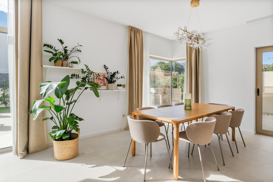 Dining table, a kitchen island with stoles, and direct access to the covered dining area and outdoors.